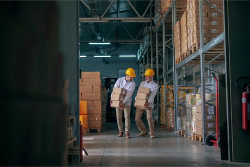 倉庫内で荷物を運ぶ二人の男性作業員